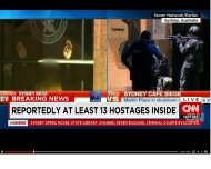 Ostatici într-o cafenea din Sidney. Le fereastră a fost arborat un steag islamic negru         