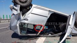 Maşină cu roţile în aer, pe A4, breteaua spre Constanţa. Geamuri sparte, haine răsturnate şi o... bancnotă (fotoreportaj)
