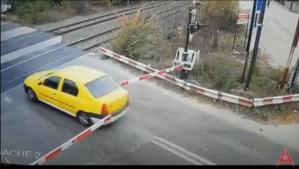 Un șofer forțează trecerea căilor ferate, printre bariere (video)