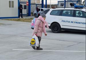 Imaginea zilei O fetiță din Ucraina poartă cu ea greutatea bagajelor...și a tragediei familiei 