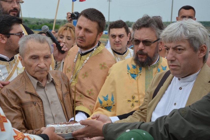 Paul Andreescu, fost deținut politic și președintele Filialei Constanța a Asociației Foștilor Deținuți Politici din România, alături de Marius Oprea și un sobor de preoți la Monumentul Memorial Poarta Albă. Sursă foto Ionuț Druche.