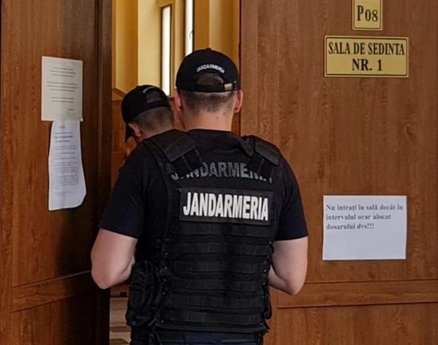 Justițiabili și jandarmi intrând în sala de judecată